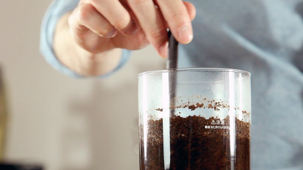 Приготовление кофе в сифоне. Шаг 12 − Выключите горелку и быстро и аккуратно перемешайте кофе. Насладитесь высвобождающимися из-под кофейной «шапки» ароматами