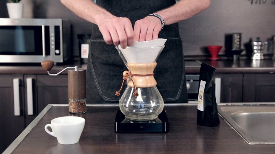 Приготовление кофе в кемексе. Шаг 4 − Разложите фильтр и установите тройной стенкой к носику кемекса;
