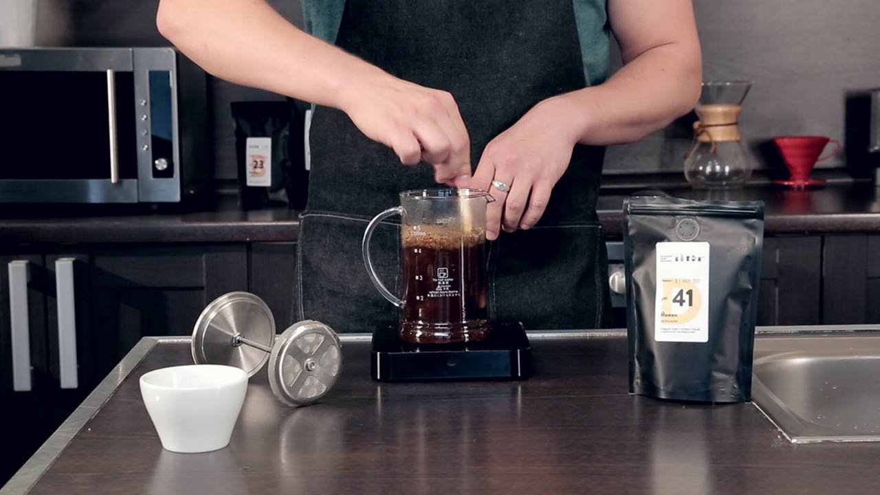 Приготовление кофе в френч-прессе. Шаг 8 − По истечении 4 минут перемешайте кофе ложкой. Накройте крышкой, но не опускайте плунжер и оставьте ещё на 5-6 минут;