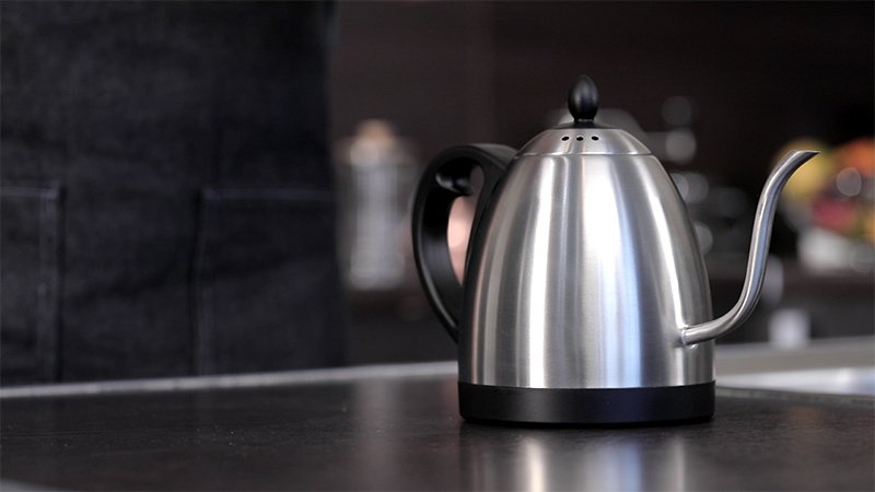 Приготовление кофе в моке. Шаг 1 − Подогрейте воду в чайнике, не доводя до кипения. Если заливать в основание холодную воду, то время приготовления сильно увеличивается, и такой кофе из гейзерной кофеварки может начать горчить, а также приобрести нежелательный металлический привкус;